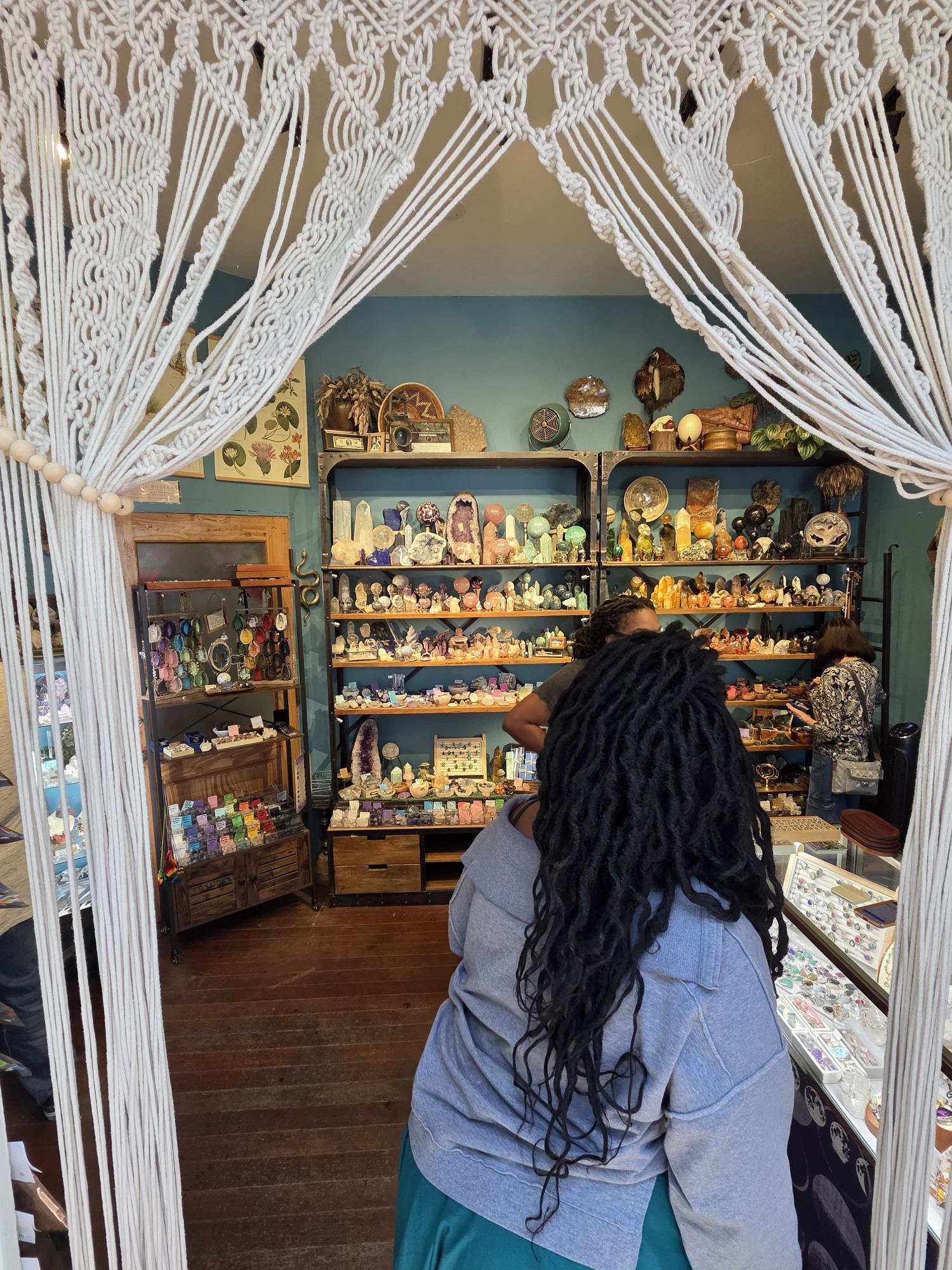 Guests browsing crystals together through a handwoven macrame archway on a private crystal tour