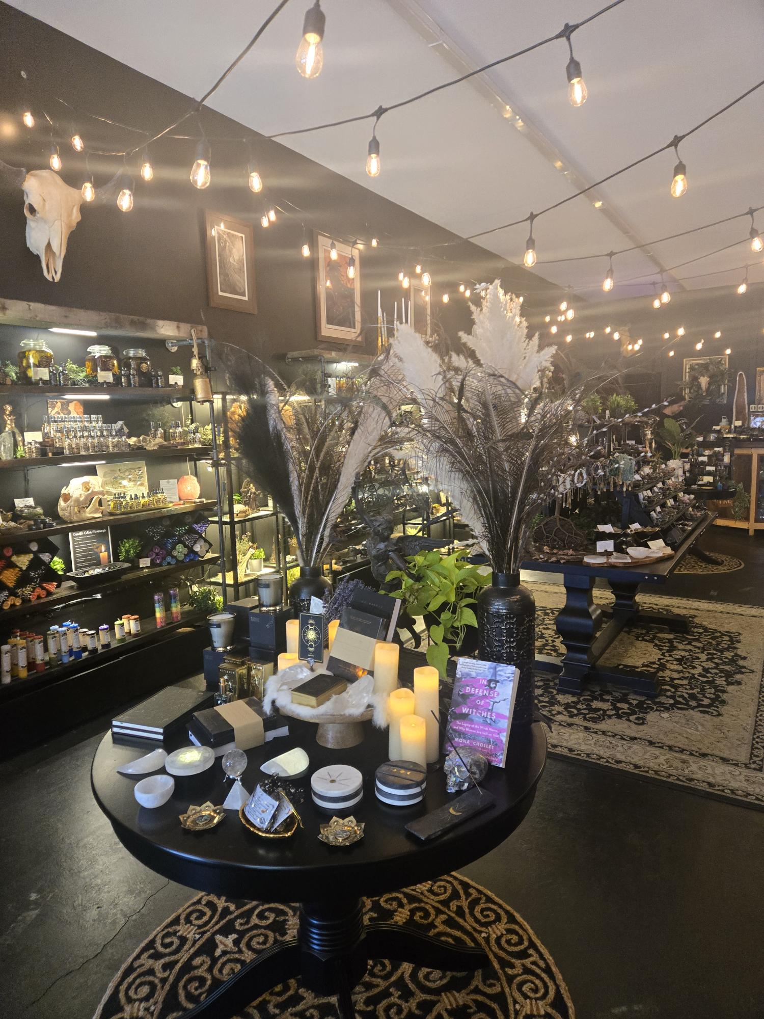 A moody candlelit interior with pampas grass, crystals, and warm Edison bulb lighting